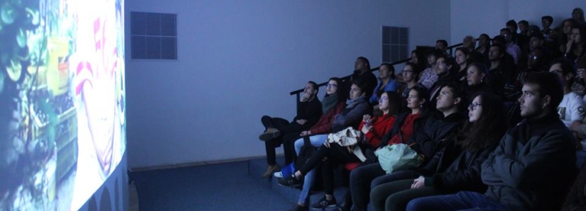 un grupo de personas frente a una pantalla viendo una audiovisual
