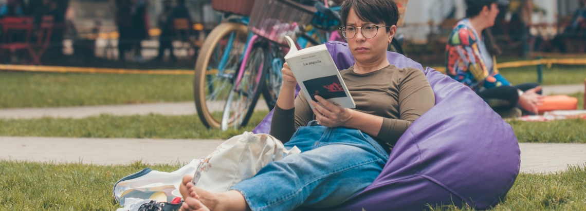 Mujer leyendo sentada en el Pícnic Literario. Foto: Cristhian Pérez / Idartes.