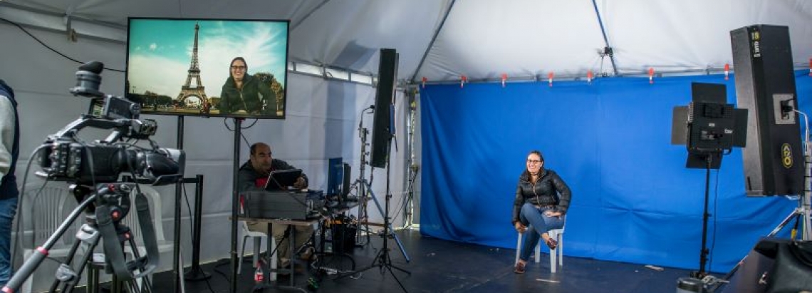 Set de grabación con una mujer posando frente a las cámaras. 