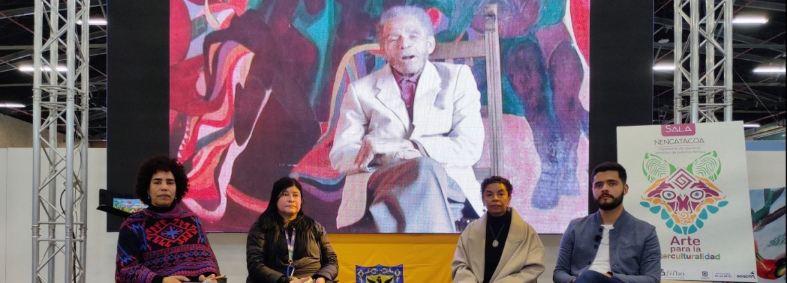 4 personas sentadas en la tarima de la sala Nencatacoa, donde se lanzó la exposición virtual