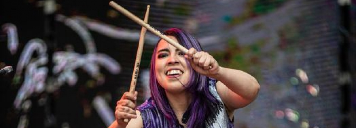 Mujer tocando la batería de día