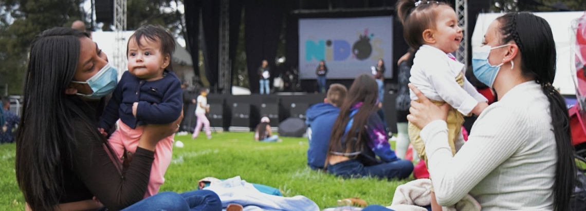 dos mujeres con sus bebés en un parque