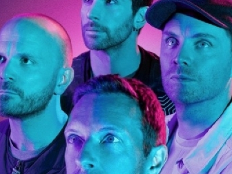 Cuatro integrantes de la agrupación Coldplay en un fondo morado. 