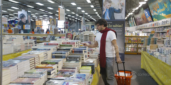 Hombre viendo libro en estand de la Feria del Libro