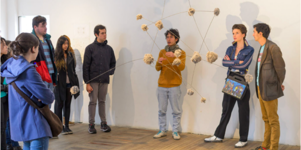 Personas participando en una charla en medio de una exposición artística