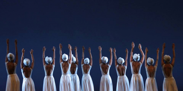 Bailarinas con trajes blancos de falda larga y sombrero danzando.