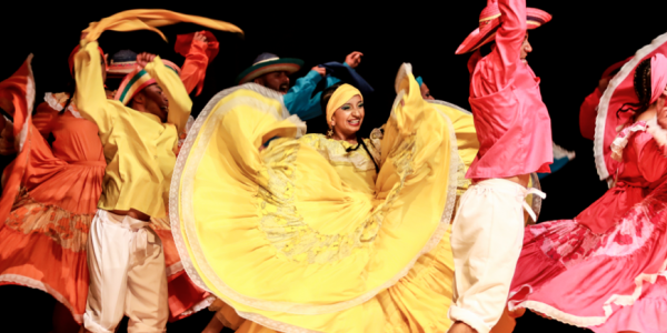 Hombres y mujeres danzando con vestidos coloridos y alegres
