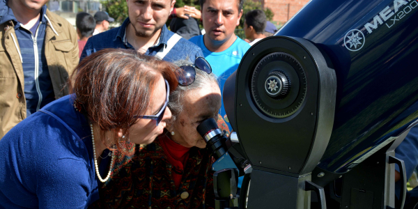 Personas observando a través del telescopio
