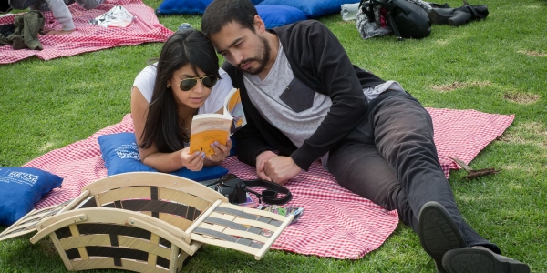Dos personas disfrutando de la lectura al aire libre.