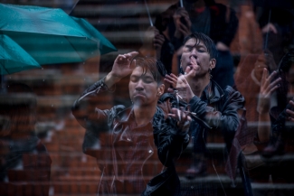 Dos hombres disfrutando del espectáculo bajo la lluvia.