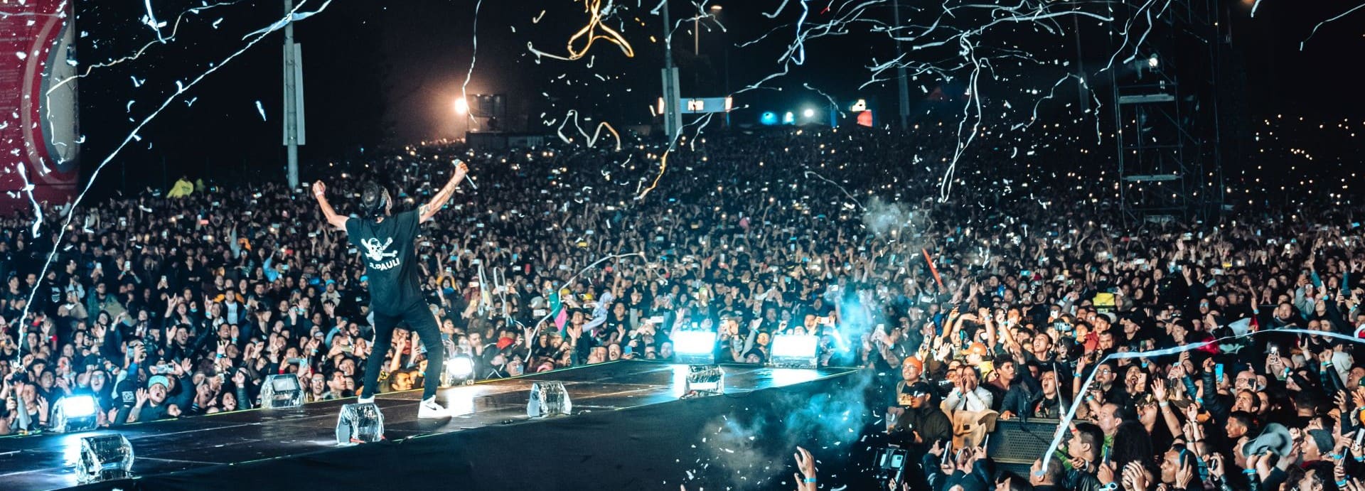 Persona sobre un escenario con público alrededor