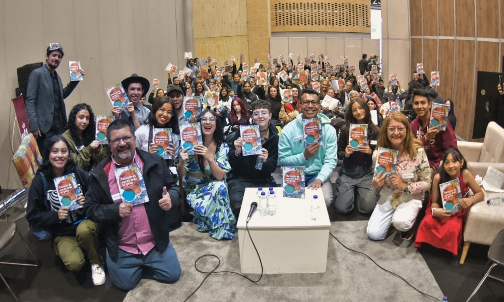 Un grupo de personas se reunen para mostrar ejemplares de una antología literaria.