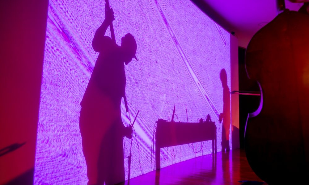 Sombras de Santiago Botero y Diego Herrera proyectadas en la pared del auditorio del planetario durante su presentación
