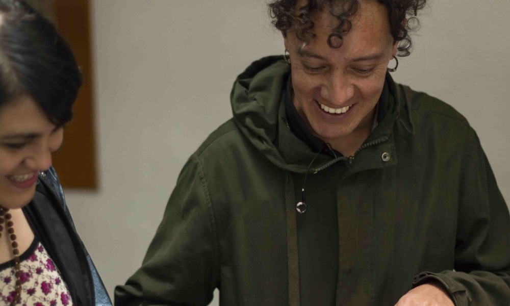 dos personas sonrien mientras miran hacia abajo