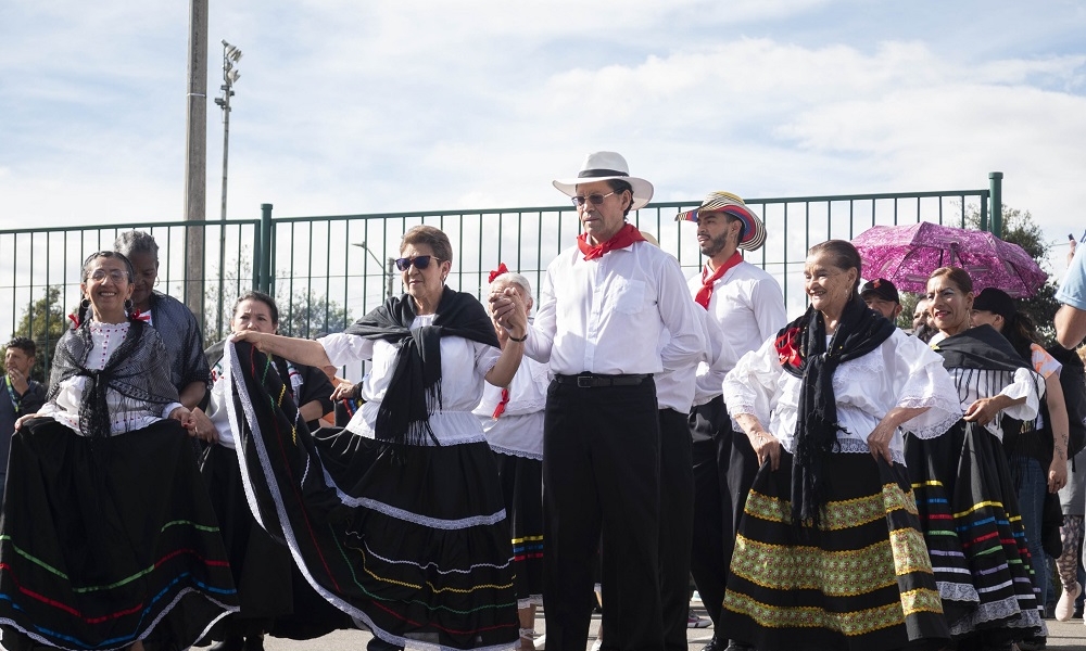 Un grupo de personas mayores bailan en un parque