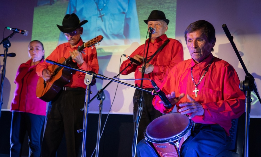 Un grupo de personas se reunen para mostrar ejemplares de una antología literaria.