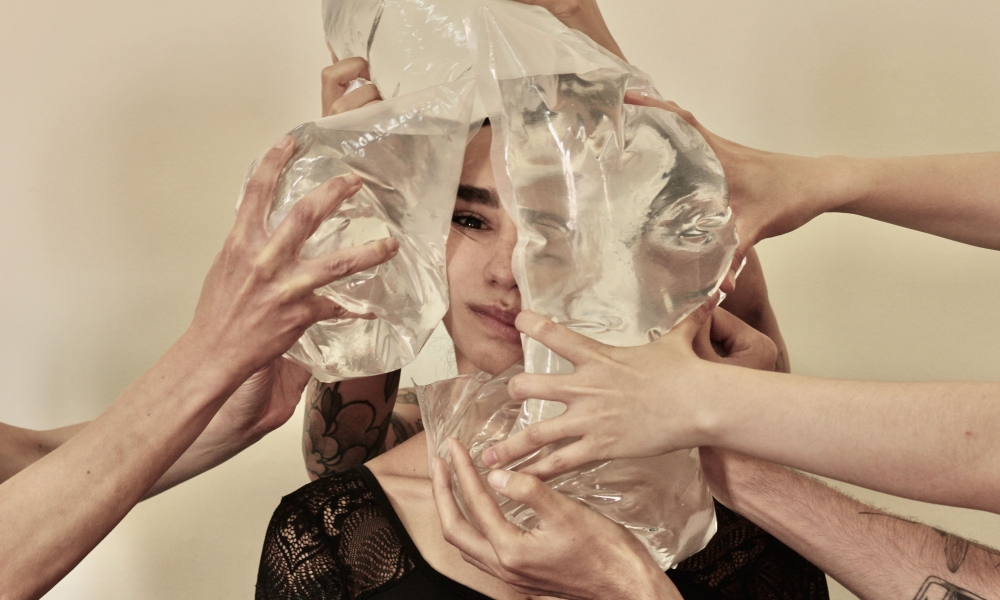 Persona rodeada de muchas manos con bolsas de agua 