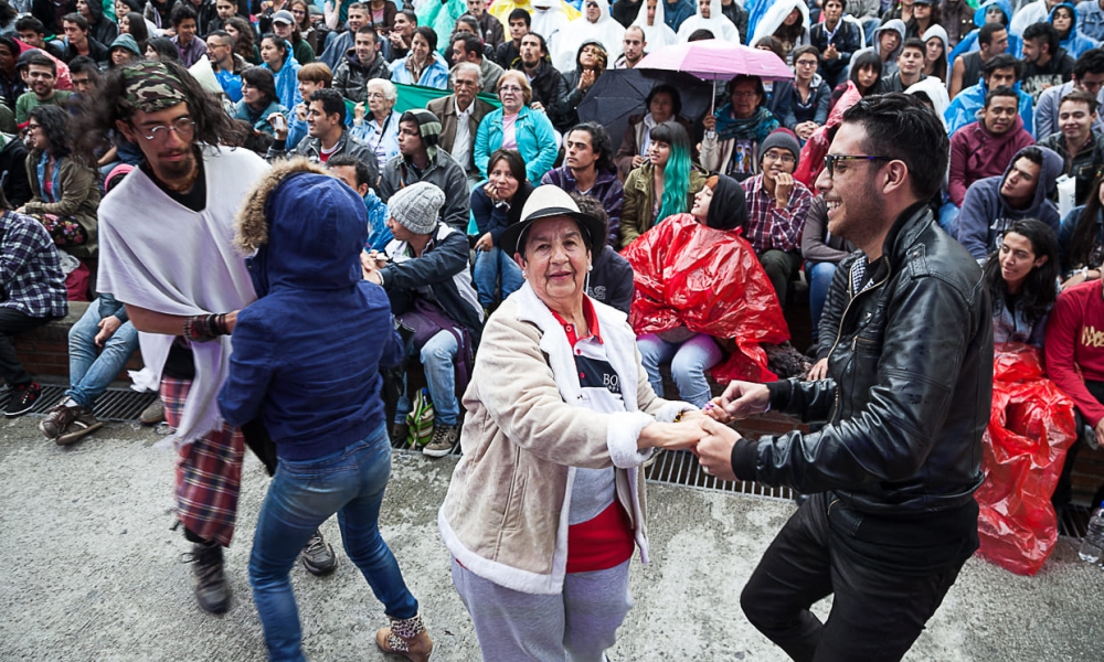 Imagen de personas participando de baile y otro público mirando actividad