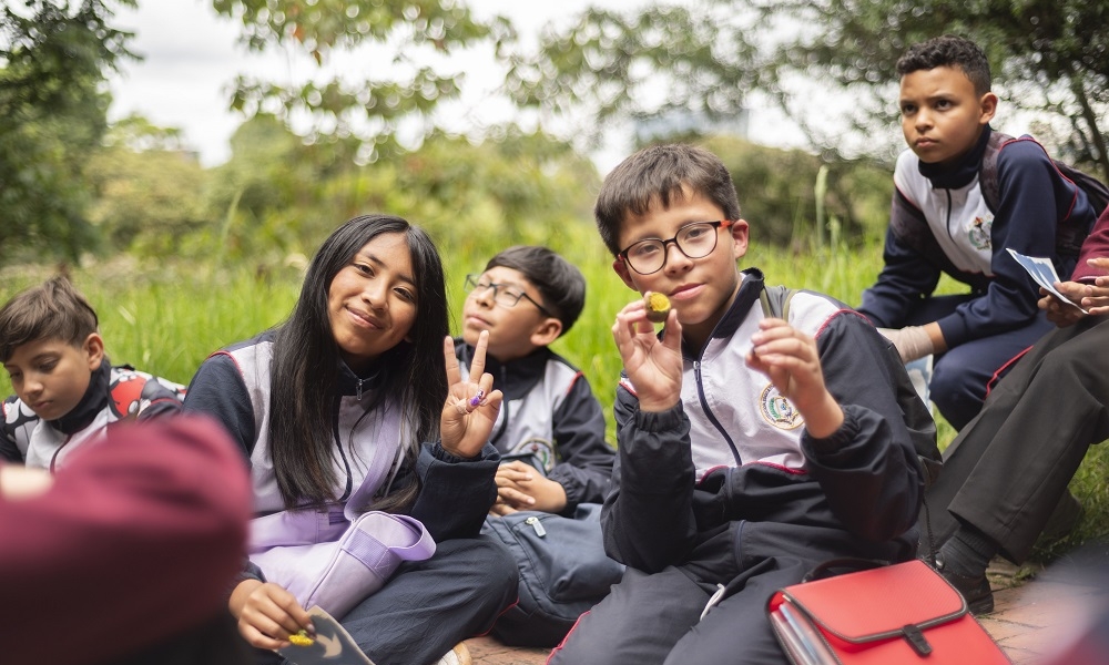 Un grupo de niños en uniforme de colegio, sonrien a la cámara.