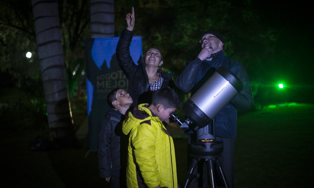 Campamento de astronómico niños observando por un telescopio.