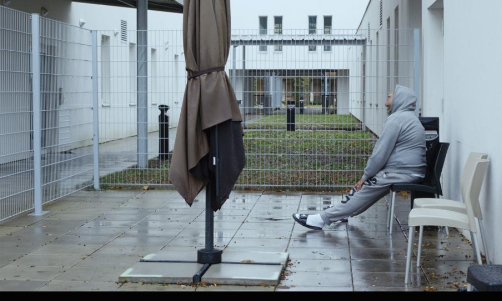 Foto de la película 12 Días Hombre sentado en una silla en el patio