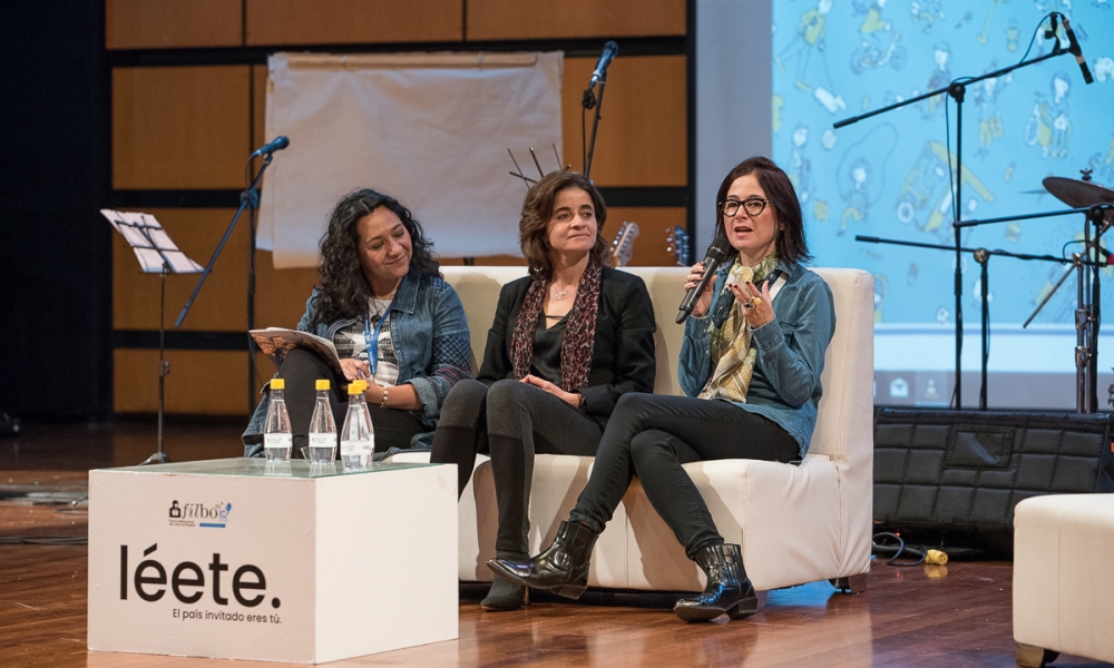 Mujeres conversan en auditorio