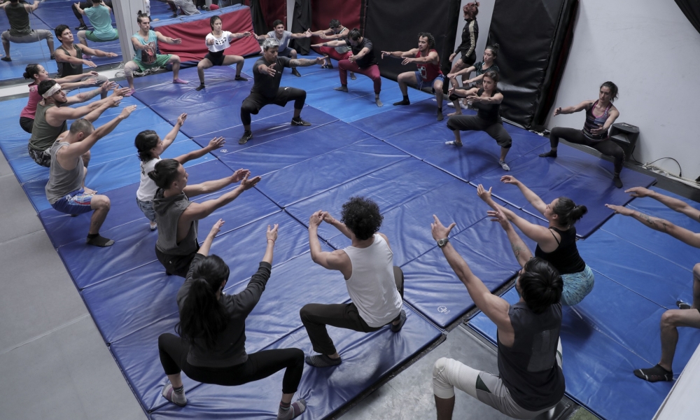 Taller de Acrobacia con Julián Moreno Acróbatas en actividad práctica, agachados haciendo ejercicios del taller.