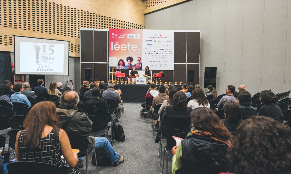 Auditorio personas escuchando a dos conversadores