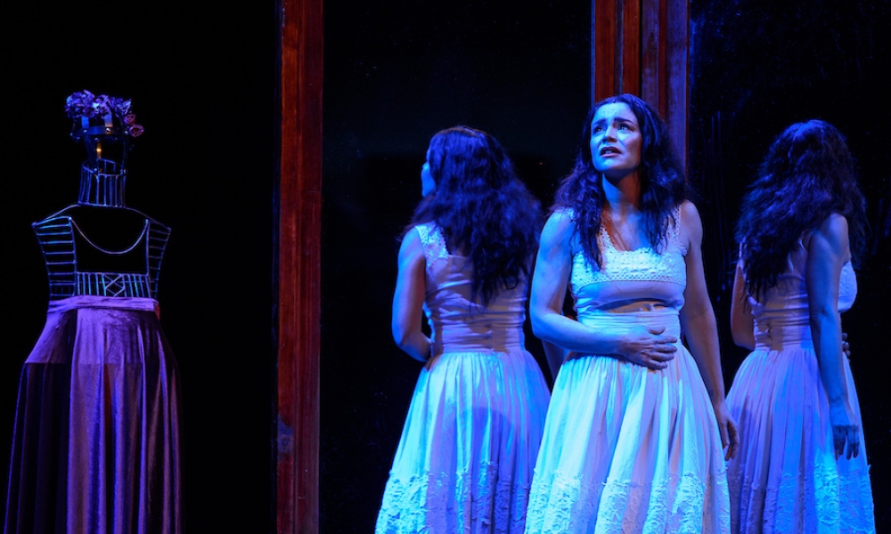 Mujer en vestido blanco en una obra de teatro con fondo negro. Mujer en vestido blanco en una obra de teatro con fondo negro.