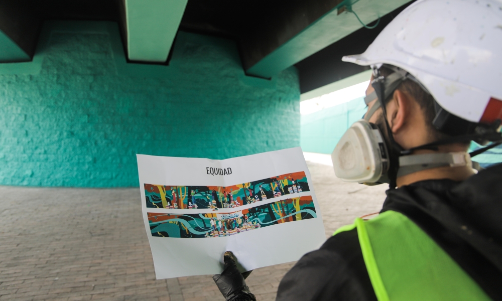 Museo Abierto de Bogotá - Puente de la 170 con Autopista Norte. Foto: Kadir: Molano / Idartes. Hombre ve un diseño de papel para plasmarlo en el puente de la 170, en el marco del Museo Abierto de Bogotá. Foto: Kadir Molano / Idartes.