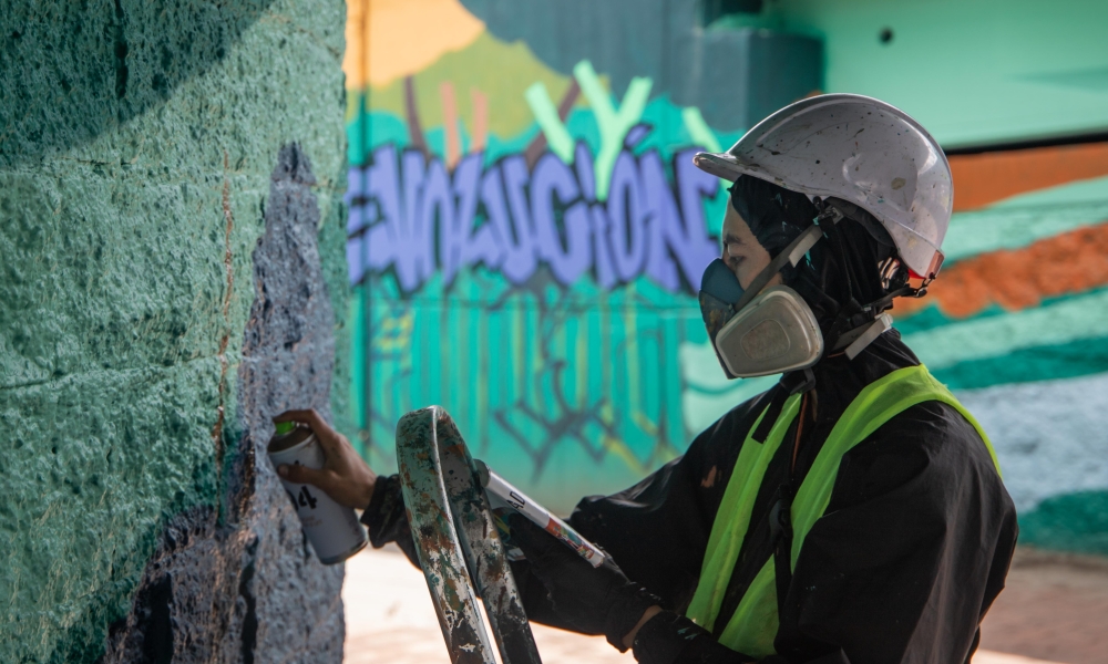 Museo Abierto de Bogotá - Puente de la 170 con Autopista Norte. Foto: Kadir: Molano / Idartes. Mujer artista hace una intervención con pintura en la Zona Bajo Puente de la 170. Foto: Kadir Molano / Idartes.