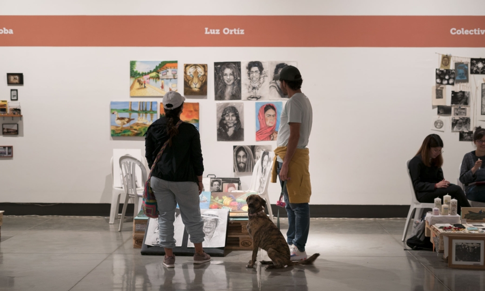 Pareja y perro observando los puestos de los artistas de las FLA en La Galería Santa Fe Pareja y perro observando los puestos de los artistas de las FLA en La Galería Santa Fe