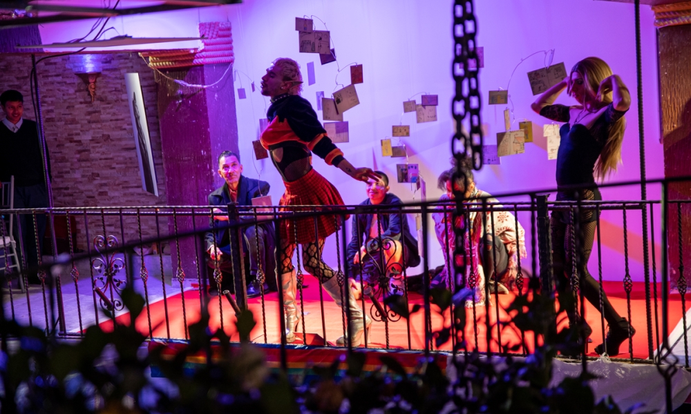 La Toma Cultural Circuito Mujeres: Aquelarre de Brujas se realizará el 28 de octubre en El Castillo de las Artes. Dos bailarines en tarima con tres bailarines de fondo en interior de noche