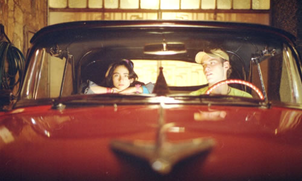Película El carro Niño y joven montados en un carro rojo