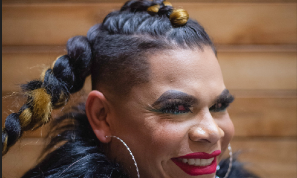 Samantha hace parte del ensamble artístico LEs FantastiquEs. Retrato de mujer trans sobre fondo de madera de día
