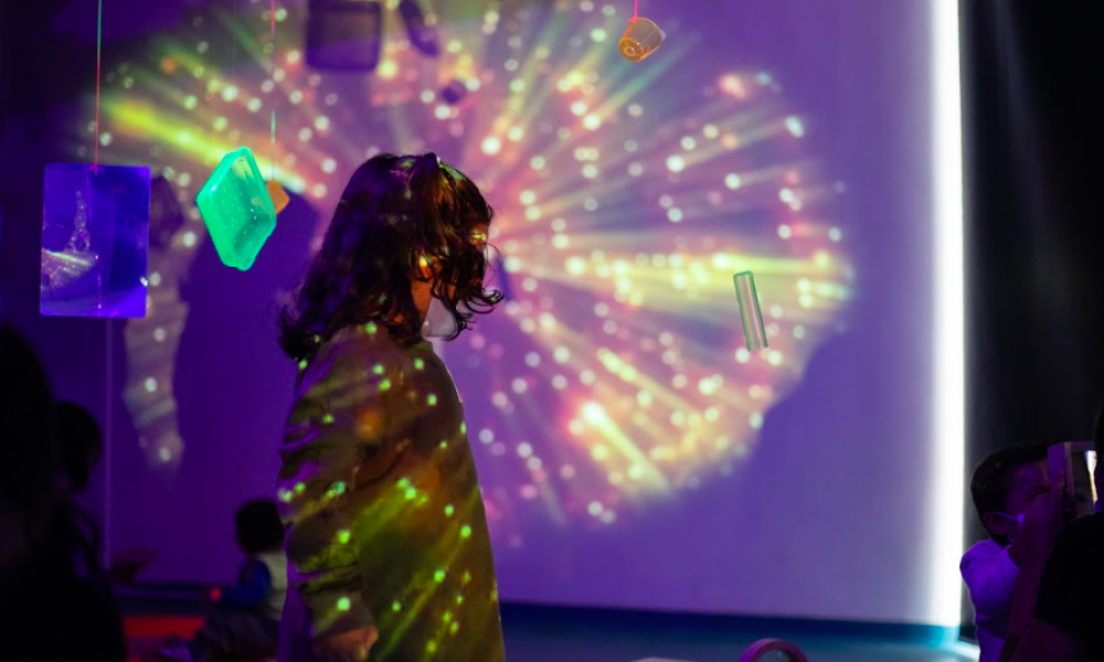 Niña con un juego de sombras y luz Sala Rayito