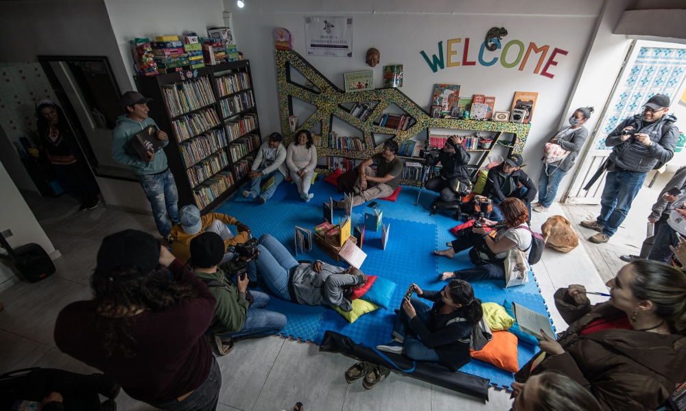 Grupo de personas reunido en una biblioteca de día.