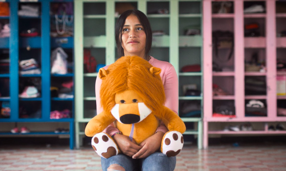 Película Alis Niña con un peluche de león en la mano