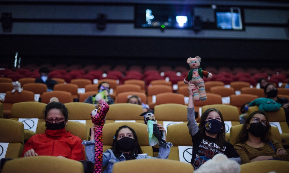 Niños con títeres Niños y niñas sentados en la Cinemateca con títeres en las manos