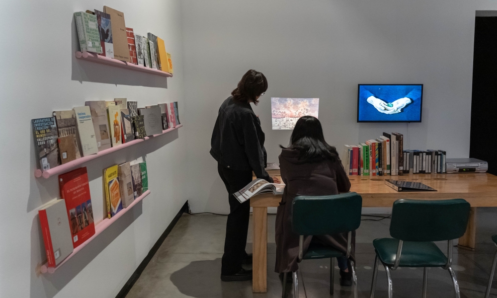 Exposición Archivo a la carta dos mujeres viendo una proyección en una pared