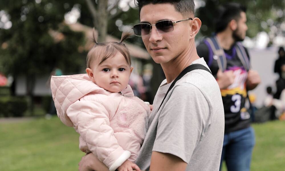 Al Parque con mi Pa´ Papá joven con niña en brazos