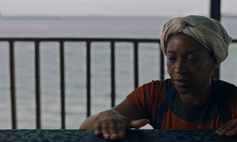 Película Puentes en el mar Mujer afro con una mano sobre una mesa