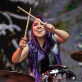Mujer tocando la batería de día