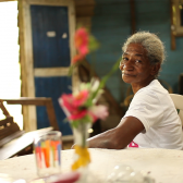 Mujer Afro sentada en un comedor 