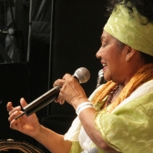 Totó la Momposina en escena vestida de verde y blanco