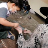 Niño en primera infancia jugando con artista de Nidos