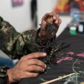 Uno de los artistas de las FLA trabajando su obra con alambre