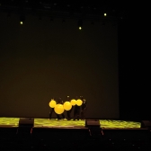 Artistas jugando con globos amarillos en la tarima