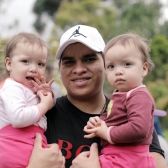Papá con sus dos hijas en brazos