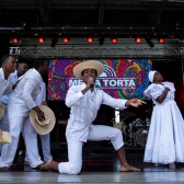Personas con atuendos colombianos autóctonos bailando 